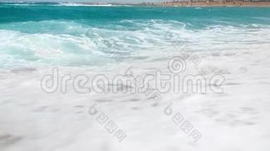慢动作，美丽的视频蓝色海浪冲破海岸线。 沙滩上的海浪